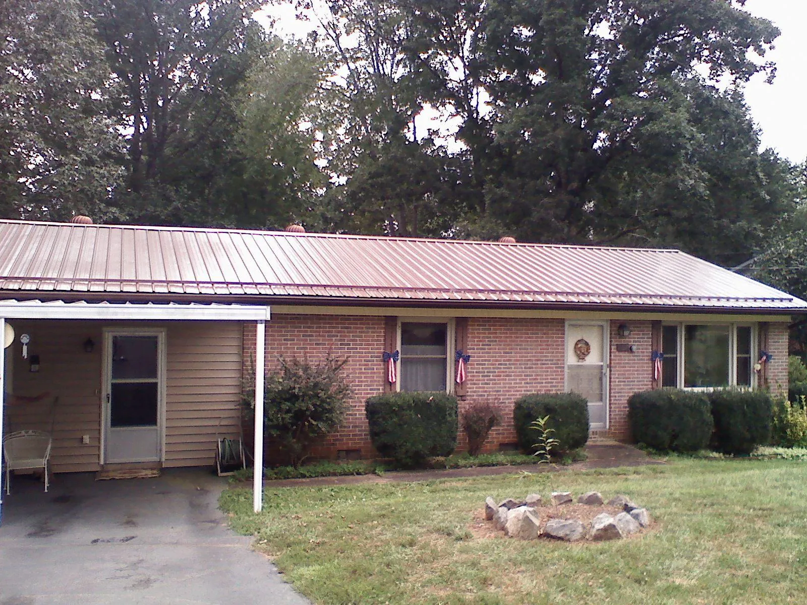Bronze metal roof and carport on a brick ranch home — Roof Repair work by our crew in Dewitt